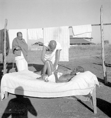 Mahatma Gandhi Sevagram Ashram, Vardha, Maharashtra, Hindistan, 1940 'ta cüzzamlı bir hastaya masaj yapıyor.