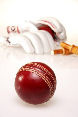 Arka planda eldivenli ve kefaletli kriket topu 