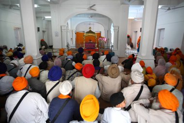 Gurudwara 'da oturan ve Anandpur Sahib, Rupnagar Bölgesi, Punjab, Hindistan' da dini vaazlar dinleyen dindarlar. 