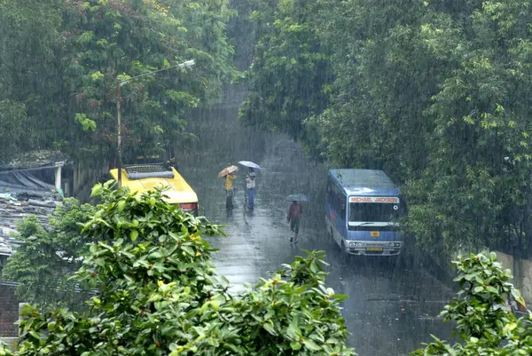 stock image Very Heavy Rain with Greenery, Road, Busses and College Girls Talking in Umbrella at Dahisar West, Bombay Mumbai, Maharashtra, India, Asia 