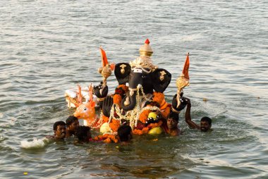 People carrying idol of lord ganesh immersed in pond on ganpati festival , Muthannankulam , Coimbatore , Tamil Nadu , India clipart