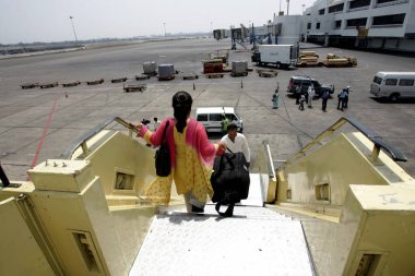 A passenger getting down from board of the airplane parked at the Chhatrapati Shivaji International Airport formerly called as Sahar International airport, Bombay Mumbai, Maharashtra, India  clipart