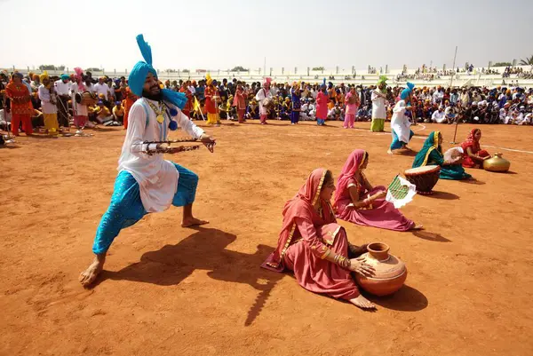 Genç Sih oğlanları ve kızlar, Guru Granth Sahib, Nanded, Maharashtra, Hindistan 'ın 300. yılını kutlamak için düzenlenen kültürel etkinlikler sırasında Bhangra halk dansını icra ediyorlar. 