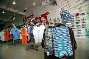 Andheri, Bombay Mumbai, Maharashtra, Hindistan 'daki Yağmacılık mağazasında sergilenen ayakkabı ve tişörtler 