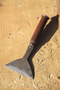 Ahşap masadaki eski paslı baltanın yakın görüntüsü.