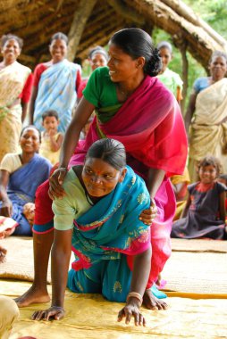 Ho kabilelerinden kadınlar sırtına biniyor ve tıbbi bilgileri paylaşıyorlar, Chakradharpur, Jharkhand, Hindistan  