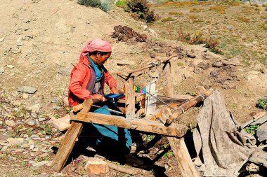 Woman weaving woollen on handloom, Muktinath, Nepal    clipart