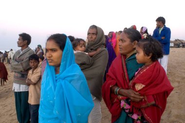 İnsanlar sabahın erken saatlerinde Hindistan 'ın Konarak tapınağı yakınlarındaki Chandrabhaga' da, Konarak, Orissa, Hindistan 'da ilk güneş ışığının dünyaya vuruşunu görmek için toplanıyorlar. 