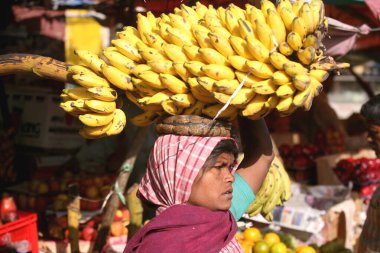 Hindistan 'ın Ranchi şehrinin başkenti Jharkhand' da kafasında muz taşıyan bir kadın. 