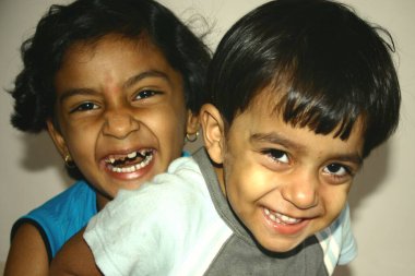 İki çocuk birlikte eğleniyor ve gülüyor, Maharashtra, Hindistan 