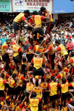 Human pyramid trying to break Dahi Handi Dadar Mumbai Maharashtra India Asia  clipart