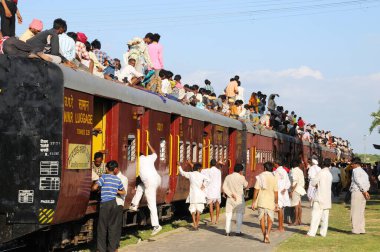 İnsanlar riskli seyahat için trenin çatısına tırmanıyor, Marwar tren istasyonu, Rajasthan, Hindistan 