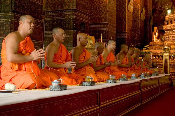 Buddhist Monks performing prayer , The Grand Palace , Bangkok , Thailand