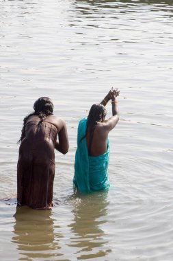 Kadınlar Varanasi, Uttar Pradesh, Hindistan 'da banyo yaparken Ganga Nehri' ne dua ediyorlar. 