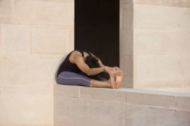 Paschimottanasana yapan kadın, Rajasthan, Hindistan, Asya