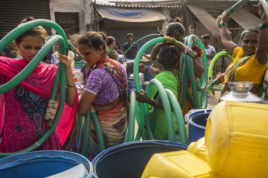 İnsanlar su tankerinden, Bhiwandi 'den, Maharashtra' dan, Hindistan 'dan plastik varillere su dolduruyorlar. 