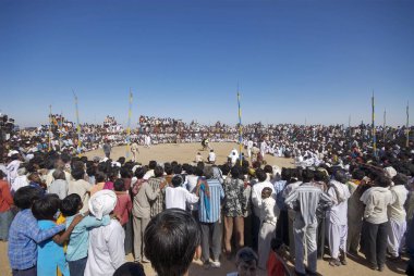 İnsanlar Bakh Mal Akhada 'nın Shivratri panayırı, Kutch, Gujarat, Hindistan' da güreşmesini izliyor. 