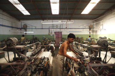 Hindistan, Maharashtra 'daki Malegaon tekstil kasabasında dokuma tezgahında çalışan bir işçi.   