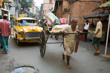 Man pulling hand rickshaw, street scene in Calcutta now Kolkata, West Bengal, India 