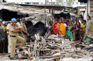 Bombay, Maharashtra, Hindistan 'daki Mankhurd Link Yolu' ndaki gecekondu mahallelerinin yıkımı sırasında meydana gelen uygunsuz olayları önlemek için polis memurları nöbet tutuyor. 