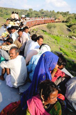 İnsanlar trenin çatısında seyahat ederken risk alıyorlar, Goram ghat, Marwar Junction, Rajasthan, Hindistan 