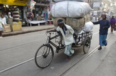 Worker pulling bale on tricycle rickshaw Kolkata West Bengal India Asia  clipart