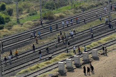 Yolcular tren raylarında yürürken yerel tren hatları raydan çıktı; Bombay Mumbai; Maharashtra; Hindistan