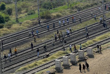 Commuters walk on railway tracks train services disrupted by local derailed ; Bombay Mumbai ; Maharashtra ; India clipart