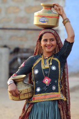 Rabari girl carrying vessel, Bhuj, Kutch, Gujarat, India   clipart