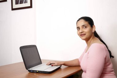 Dizüstü bilgisayarda çalışan Hintli kadın 