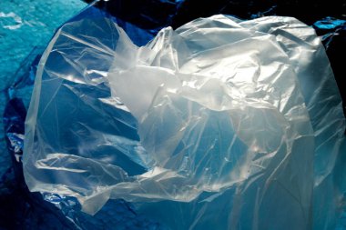 Mavi renkli selofan kağıdın üzerindeki plastik alışveriş torbası soyut.