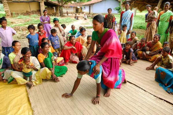 Ho kabilelerinden kadınlar sırtına biniyor ve tıbbi bilgileri paylaşıyorlar, Chakradharpur, Jharkhand, Hindistan   