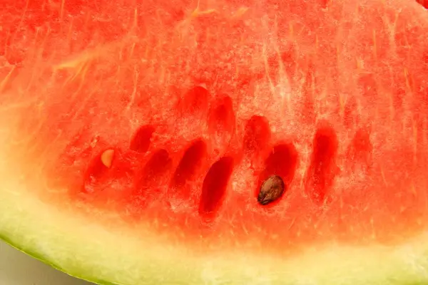Fruits ; One slice of watermelon showing red watery pulp and one black seed ; Pune ;  Maharashtra ; India