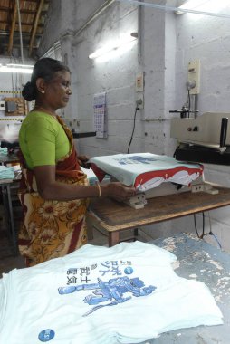 Manual fusing after printing in a garment industry ; Tirupur ; Tamil Nadu ; India clipart