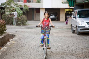7 yaşındaki Güney Asyalı Sanchi bisiklet sürüyor, Bombay Mumbai, Maharashtra, Hindistan  