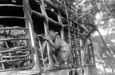 Street urchin enters burnt bus as rioters put in on fire after religious fundamentalists demolished the Babri Masjid in Ayodhya in Uttar Pradesh on 6 December 1992, The rioting continue till January 1993 in Bombay now Bombay Mumbai, Maharashtra   clipart