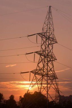 Gün batımında yüksek gerilim hattı kulesi; Pune; Maharashtra; Hindistan