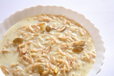 Müslüman şenlikli tatlı sevian vermicelli güzel vermicelli sütlü fındık ve safrandan yapılmış beyaz arka planda kasede