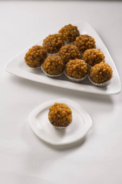 sweet ladoo snacks on plate on the table  clipart