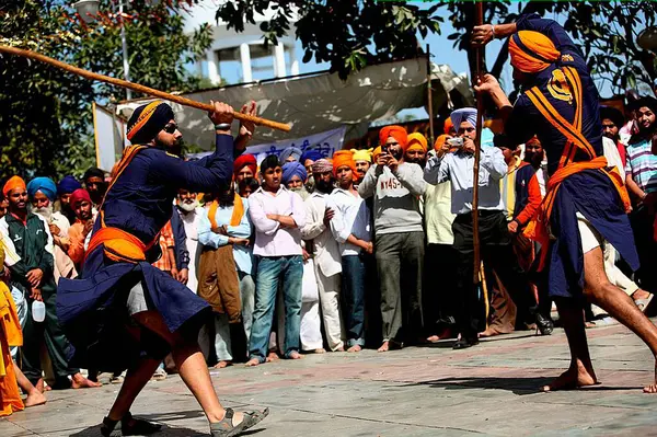 stock image Nihang or Sikh warriors performing stunts with wooden sticks in during Hola Mohalla celebrations at Anandpur sahib in Rupnagar district, Punjab, India  