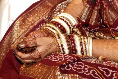 Gelin, düğün töreninde bilezik ve kınalı dövmeleri gösteriyor.