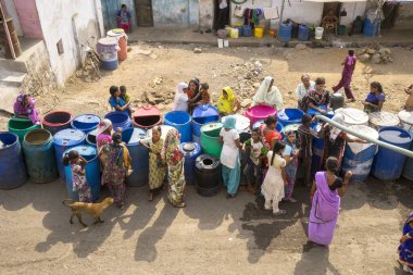 İnsanlar su tankerinden, Bhiwandi 'den, Maharashtra' dan, Hindistan 'dan plastik varillere su dolduruyorlar. 