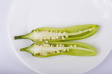 Beyaz arkaplanda dilimlenmiş yeşil biber