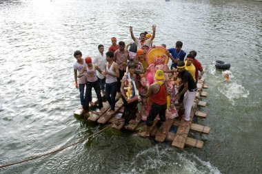 Ganpati 'yi bambu salında taşıyan gönüllüler Visarjan Jodhpur Rajasthan Hindistan Asya 