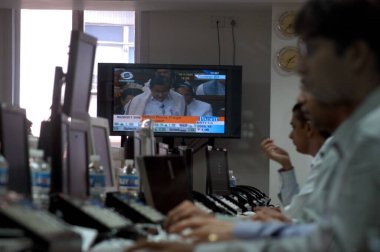 Hindistan Maliye Bakanı DR. P. Chidambaram televizyonda bütçe konuşmasını yaparken tüccarlar Bombay Mumbai, Maharashtra, Hindistan 'daki Bombay Borsası' nda (BSE) borsa saatlerinde ticaret yapıyorlar.
