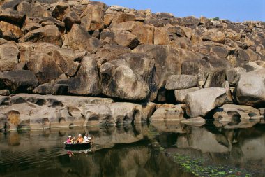 Yabancılar Tungabhadra Nehri, Hampi, Hospital, Karnataka, Hindistan 'da Coracle gezisinin tadını çıkarıyorlar. 
