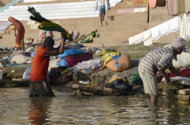 Varanasi Ghat Uttar Pradesh Hindistan 'daki Ganga nehrinde çamaşır yıkayanlar. 
