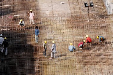 Daha önceki Jüpiter değirmenleri, Bombay Mumbai, Maharashtra, Hindistan 'da inşa edilen binalarda çalışan işçiler. 