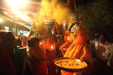 Tören sırasında tanrı ve tanrıça Rishi Jamat Agni ve Yellama 'nın bronz heykellerine sürülen zerdeçal veya Haldi; Ghatkopar' da Bewa Purnima vesilesiyle hadımların düğünü; Mumbai 'de Bombay; Maharashtra; Hindistan;