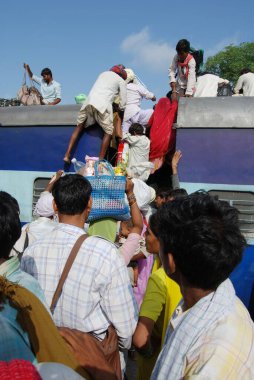 Birçok insan tren istasyonunda, Jodhpur 'da, Rajasthan' da, Hindistan 'da tren çatısına tırmanmaya çalışıyor. 